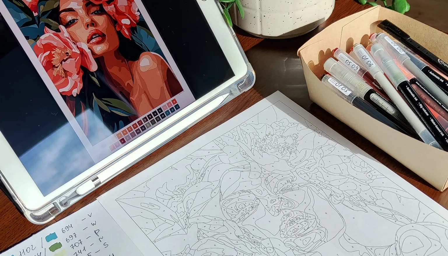 Navigation Map on a tablet next to a printed coloring page and markers matched to the color palette